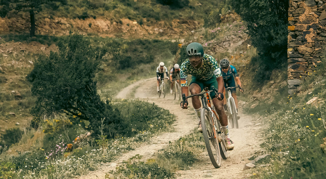 Gravel bike riders on a dirt path in a mountainous area