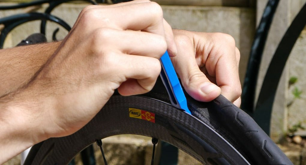 Using tire levers to remove a road bike tire