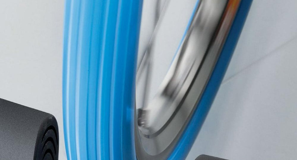Indoor trainer roller contacting a blue trainer tire